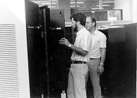 engineers looking inside cabinet